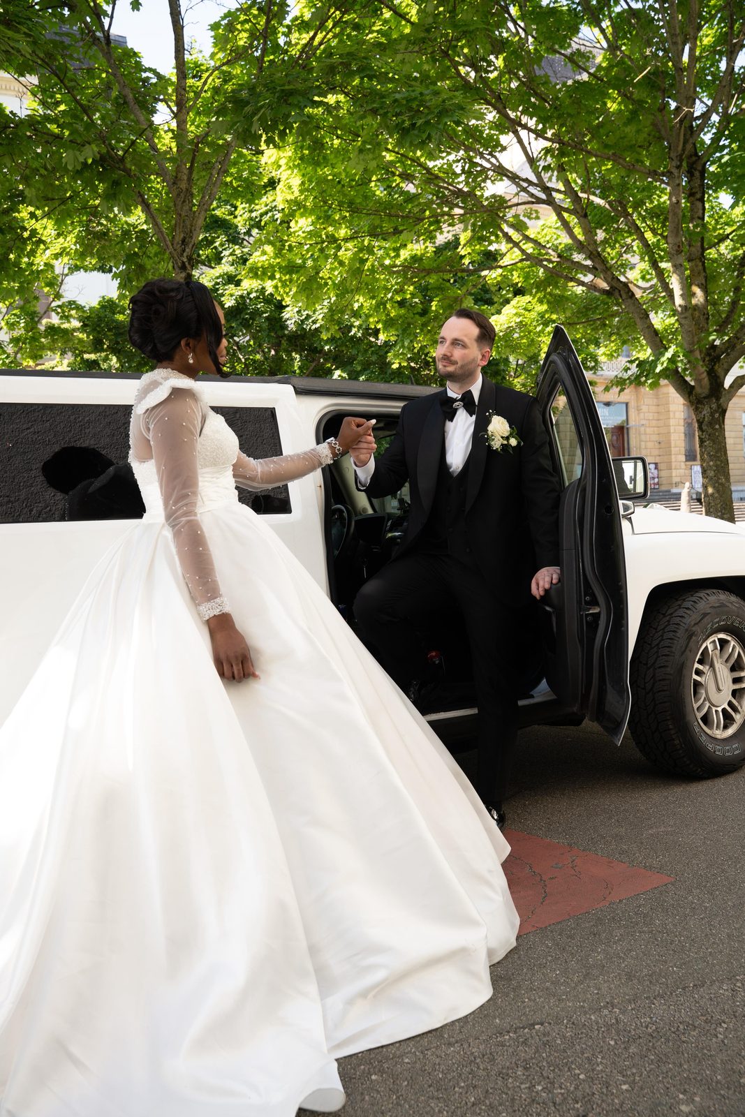 Les mariés devant une limousine blanche