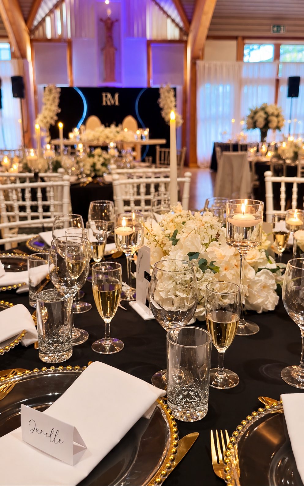 Table dressée avec bougies et fleurs blanches, le logo RM en arrière-plan